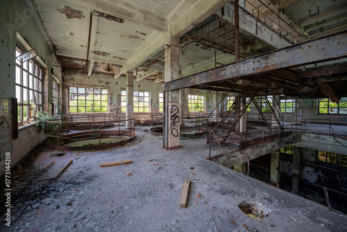 Abandoned distillery tower in Italy – circular industrial building with glass dome, steel beams, panoramic windows, decaying factory interior, urban exploration, post-industrial architecture
