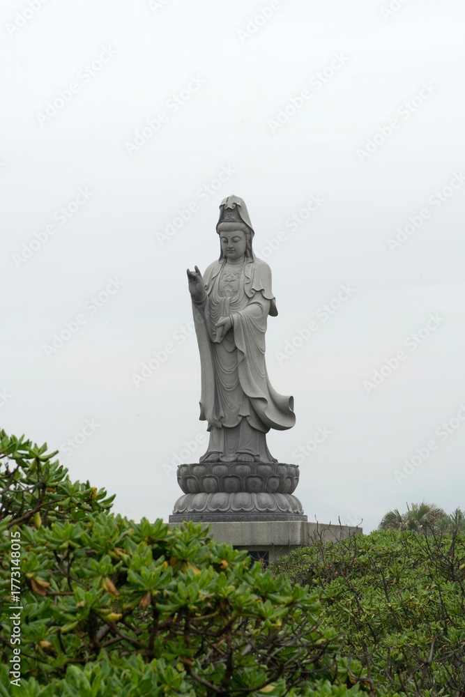 Obraz premium a white stone Buddha statue in the park