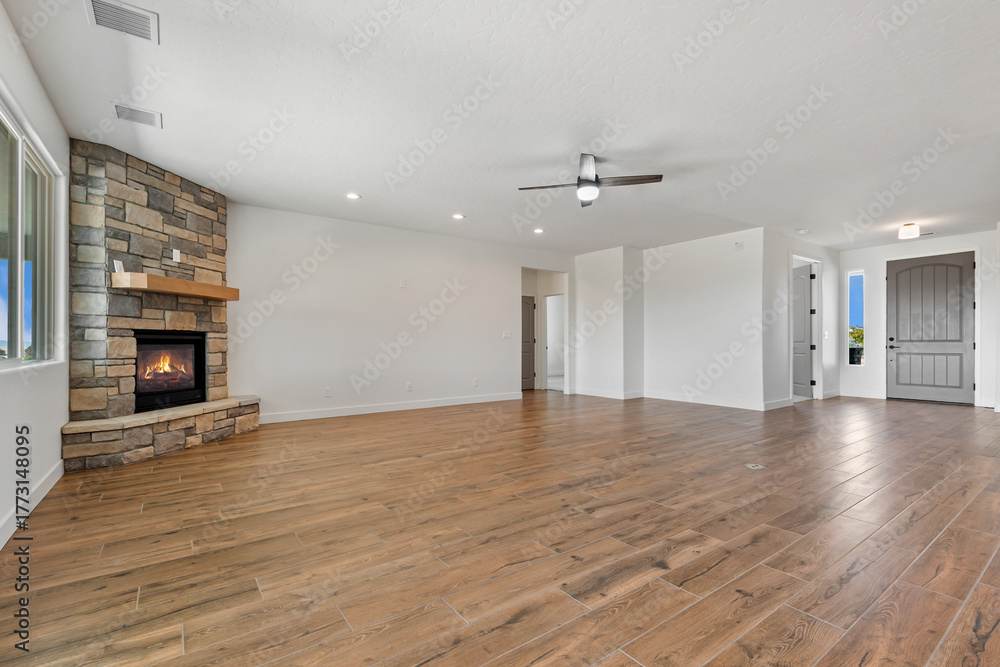Obraz premium A spacious, vacant room with hardwood flooring and a ceiling fan