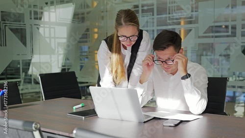 Colleagues collaborate on project in modern space.