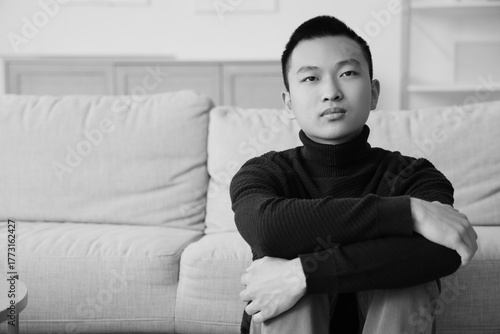 Sad young Asian man at home