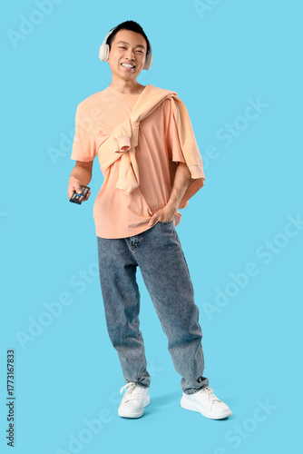 Young Asian man with TV rem...