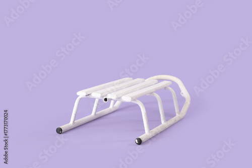 White wooden sled on purple...