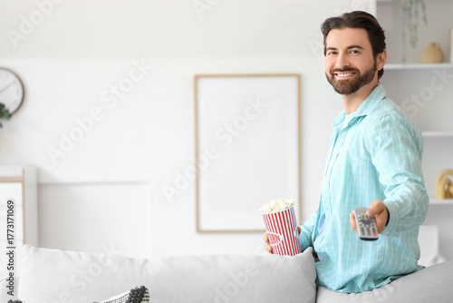 Young man with popcorn and ...