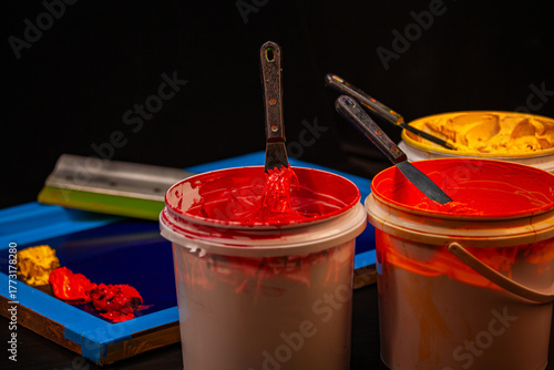 Colorful screen printing workshop scene where red, orange, and yellow inks merge across the mesh screen, illustrating the intricate manual process of creating bold and dynamic gradient prints by hand