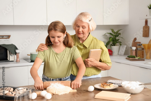 Happy girl rolling dough wh...