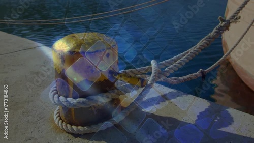 Sunlight flaring yellow bollard starting blue grid sliding over rope fading restoring pier view