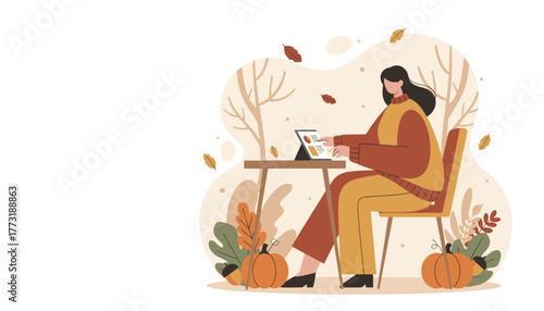 Woman working on a tablet outdoors in a cozy autumnal setting with pumpkins and falling leaves