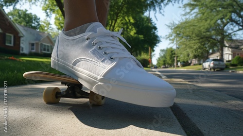 Person skateboarding on sidewalk in residential area
