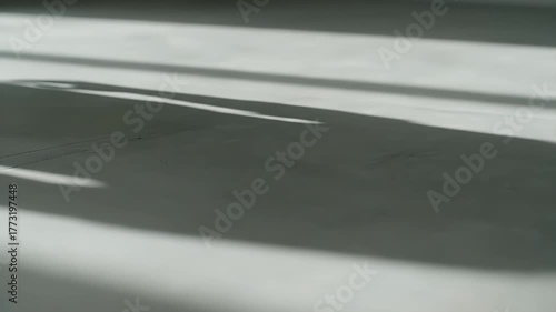 Abstract moving shadows creating patterns on a white surface.