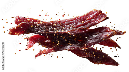 Several thin strips of dried, seasoned beef jerky sprinkled with spices, isolated on a white background