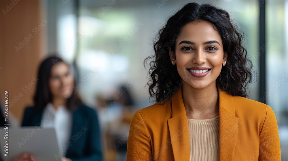 Obraz premium Confident, smiling businesswoman in a modern office exudes professionalism and success, ready to lead and innovate with a bright future ahead.