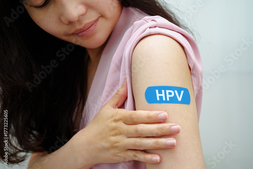 HPV, Human papillomavirus, Asian young woman receiving vaccine with blue bandage.