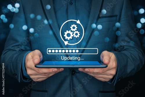 Businessman holding tablet with software update progress bar and gears icon, system upgrade concept.