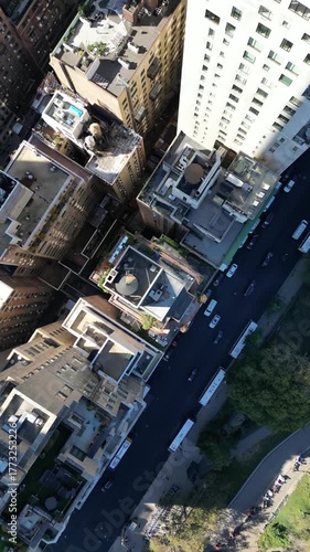 Drone spirals downward around New York City skyscraper with skyline reflections