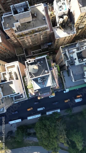 Drone spirals upward around Manhattan skyscraper revealing Central Park below