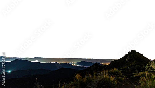 Night panorama of mountain range lit by distant cityscape lights