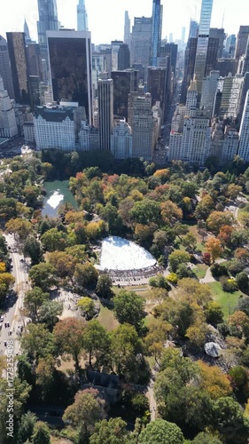 Flying above Central Park ice rink surrounded by trees and New York skyline