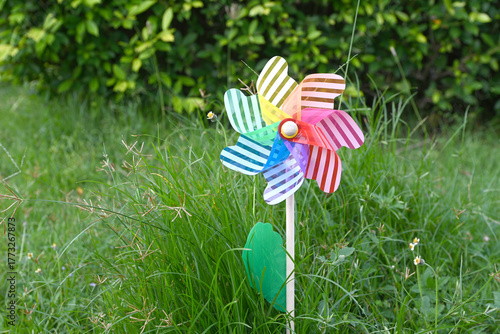 Toy windmills on a background of green grass on a Sunny summer day 