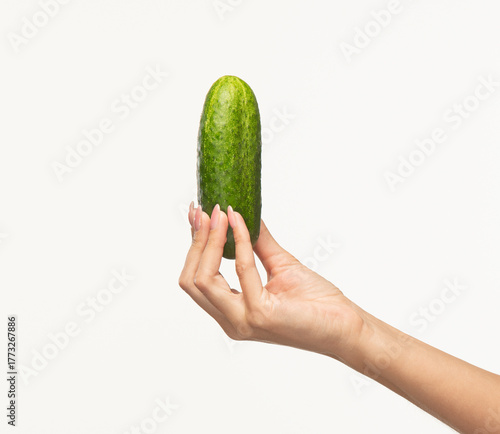 beautiful female fingers holding a cucumber