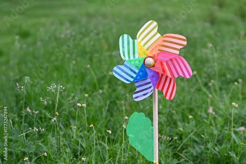 Toy windmills on a background of green grass on a Sunny summer day