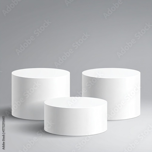 Three white, round, tiered podiums stand on a gray surface