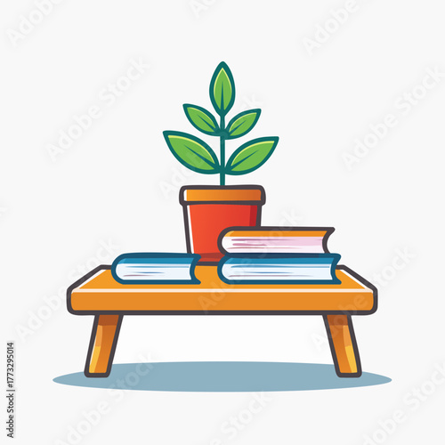 A potted plant and books on a wooden table.