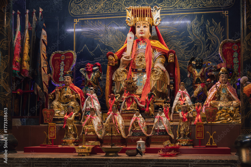 Fototapeta premium Golden chinese deity surrounded by smaller deities in a shrine