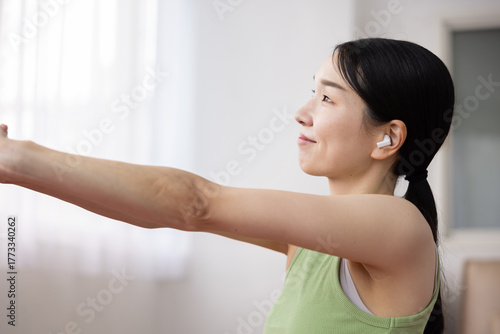 Japanese Woman Stretching on Yoga Mat with Wireless Earphones Free Download Japanese Woman Stretching on Yoga Mat with Wireless Earphones - GFXLoad