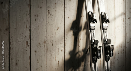 Skis leaning against wooden wall offer sporty vibes, showcasing winter sport equipment. White skis leaned in corner create cool vibe. Skis provide winter sport ideas for sporty vacation.