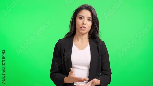 Professional hispanic woman talking to camera on green screen