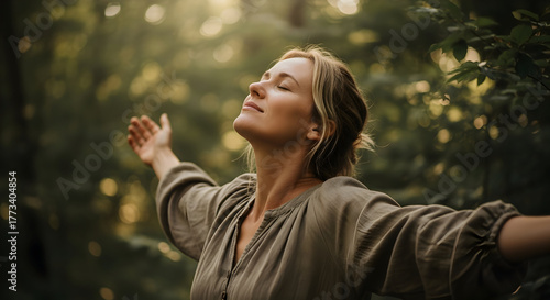 Young woman embracing freedom in nature and seeking a mindful lifestyle in a forest clearing during a tranquil sunrise