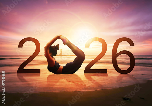Happy new year card 2026. Silhouette of healthy girl doing Yoga Bow pose on tropical beach with sunrise of sunset sky background, woman practicing yoga as a part of the Number 2026 sign.