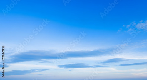 Bright blue sky with gentle soft clouds, smooth gradient tones clear and vibrant atmosphere, no sun glare, perfect lighting balance, realistic and detailed sky texture high resolution photo background