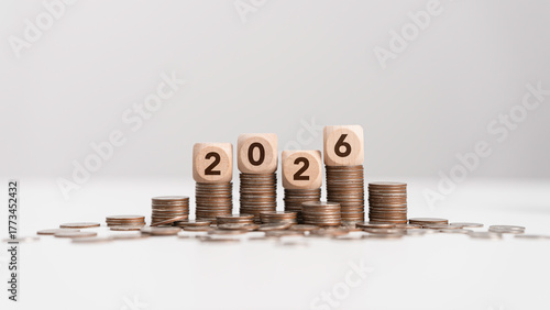 Stacks of coins with wooden blocks forming number 2026 for target financial growth, investment planning for money savings to wealth, business goals concept. Budget and tax, Happy new year 2026