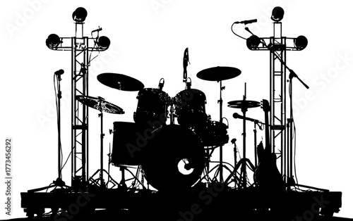 Silhouette of a complete drum set with microphones and stage lighting on a platform.
