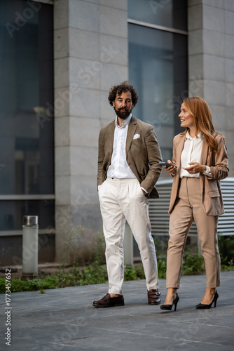 Businesspeople walking and talking outside office building