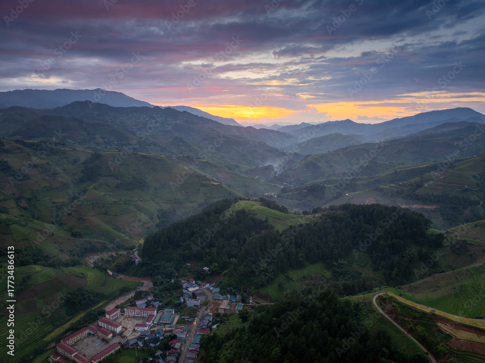 Fototapeta premium Aerial view of golden rice terraces at Mu Cang Chai town near Sapa city, North of Vietnam. Beautiful terraced rice field in harvest season in Yen Bai province.