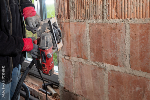 Construction Worker using a Wall Chaser to make Channels for Electric Installation