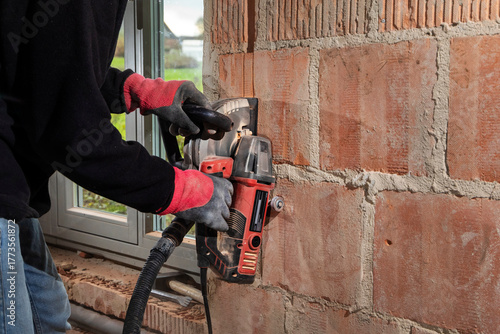 Construction Worker using a Wall Chaser to make Channels for Electric Installation