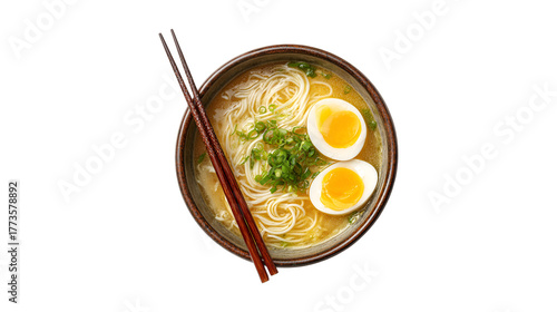 A delicious bowl of Japanese ramen noodle soup with soft boiled eggs and fresh green onions viewed from above with chopsticks resting on the side