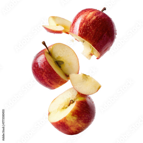 Red apples sliced and falling against a black background