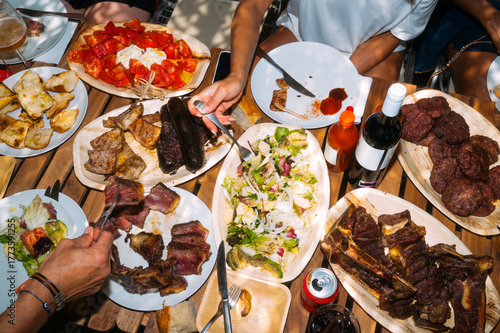 Barbecue table with assorted grilled meats and salad.