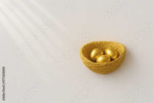 Golden nest with three metallic eggs in warm sunlight on minimalist beige background