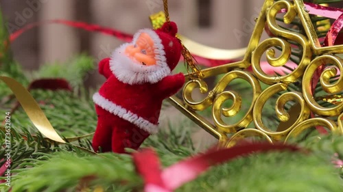 Christmas tree with decoration. Close-up decorating Christmas tree with baubles balls on the background and santa claus small toy on tree and ball on tree. Christmas party or miracles and Santa Claus.