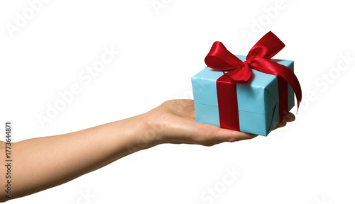 High quality PNG of close up hand with gift box is wrapped in light blue paper and tied with a red ribbon with a bow. Isolated image on a transparent background