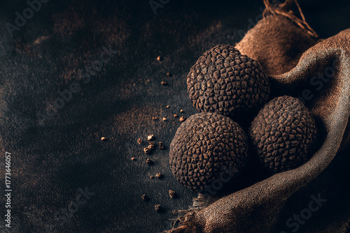 Fresh truffles arranged on a dark textured background with copy space, moody lighting