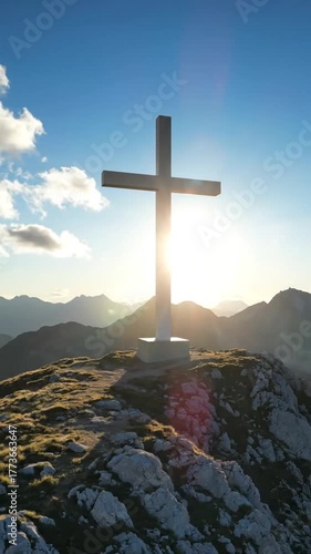 Dramatic aerial view of a stone cross on a mountain peak at sunset