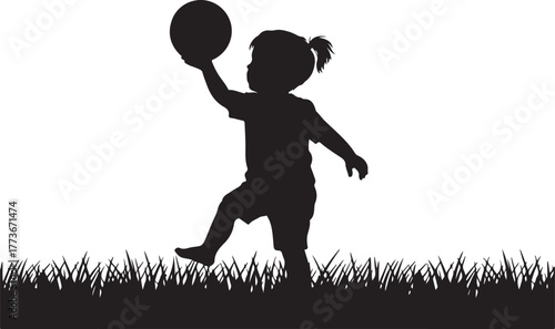 Silhouette of a young child playing with a balloon in a grassy field
