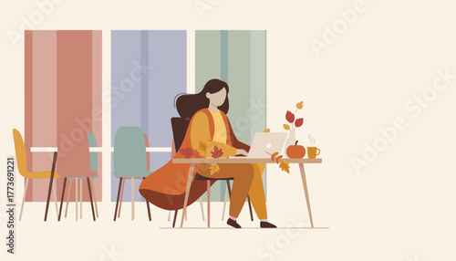 A comfortable woman working remotely on her laptop during the cozy autumn season